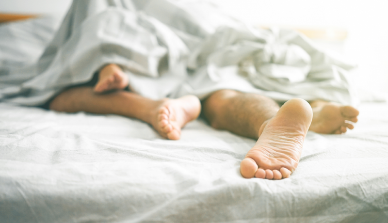 feet-of-couple-having-sex-under-sheets